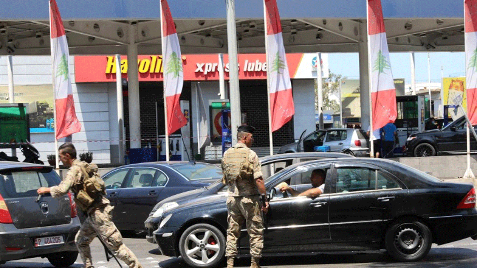 جندي لبناني يوجه حركة المرور في محطة بنزين في العاصمة بيروت يوم السبت 14 آب/ أغسطس 2021، بعد انتشار جنود لإجبار المحطات على تسليم الوقود للمواطنين.