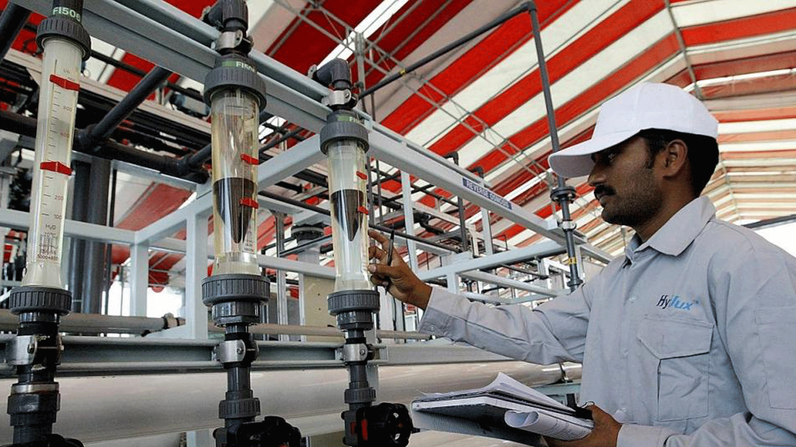 عامل يفحص مقياس المياه في محطة تحلية في سنغافورة