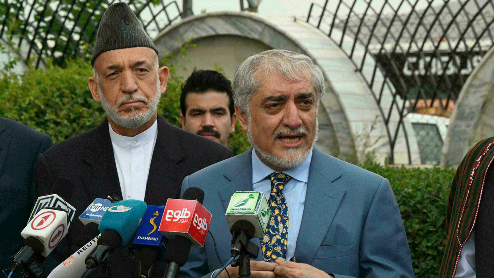 الرئيس التنفيذي الأفغاني السابق عبد الله عبد الله (وسط) والرئيس الأفغاني السابق حامد كرزاي (إلى اليسار) جزء من فريق مفاوضي كابول لإجراء محادثات في قطر مع مندوبي طالبان.
