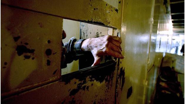 يد سجين تظهر من باب إحدى زنزانات سجن رومية اللبناني