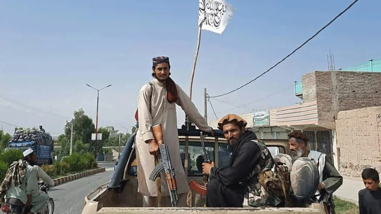 مقاتلو طالبان يقودون عربة للجيش الوطني الأفغاني.