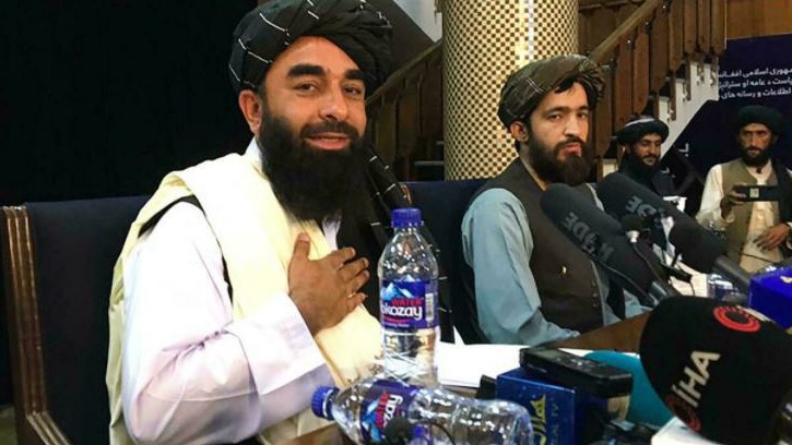 المتحدث باسم طالبان ذبيح الله مجاهد (يسار) في مؤتمر صحفي في مبنى حيث اعتادت الحكومة الأفغانية إحاطة وسائل الإعلام