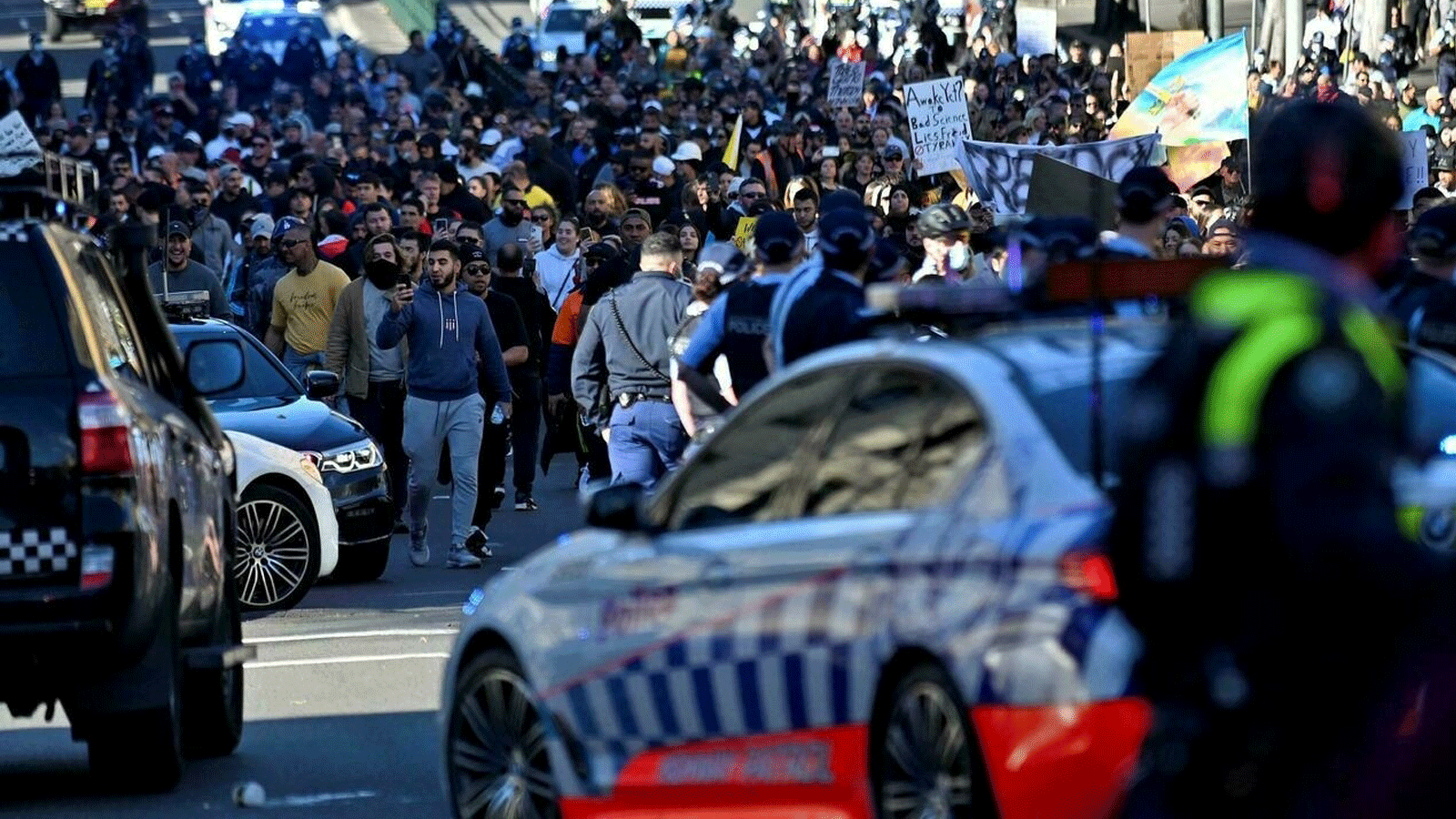 الشرطة تقطع الطريق على المتظاهرين خلال مسيرة مناهضة للإغلاق في سيدني، حيث تجمع الآلاف للتظاهر ضد أمر البقاء في المنزل لمدة شهر في المدينة. بتاريخ 24 تموز/ يوليو 2021