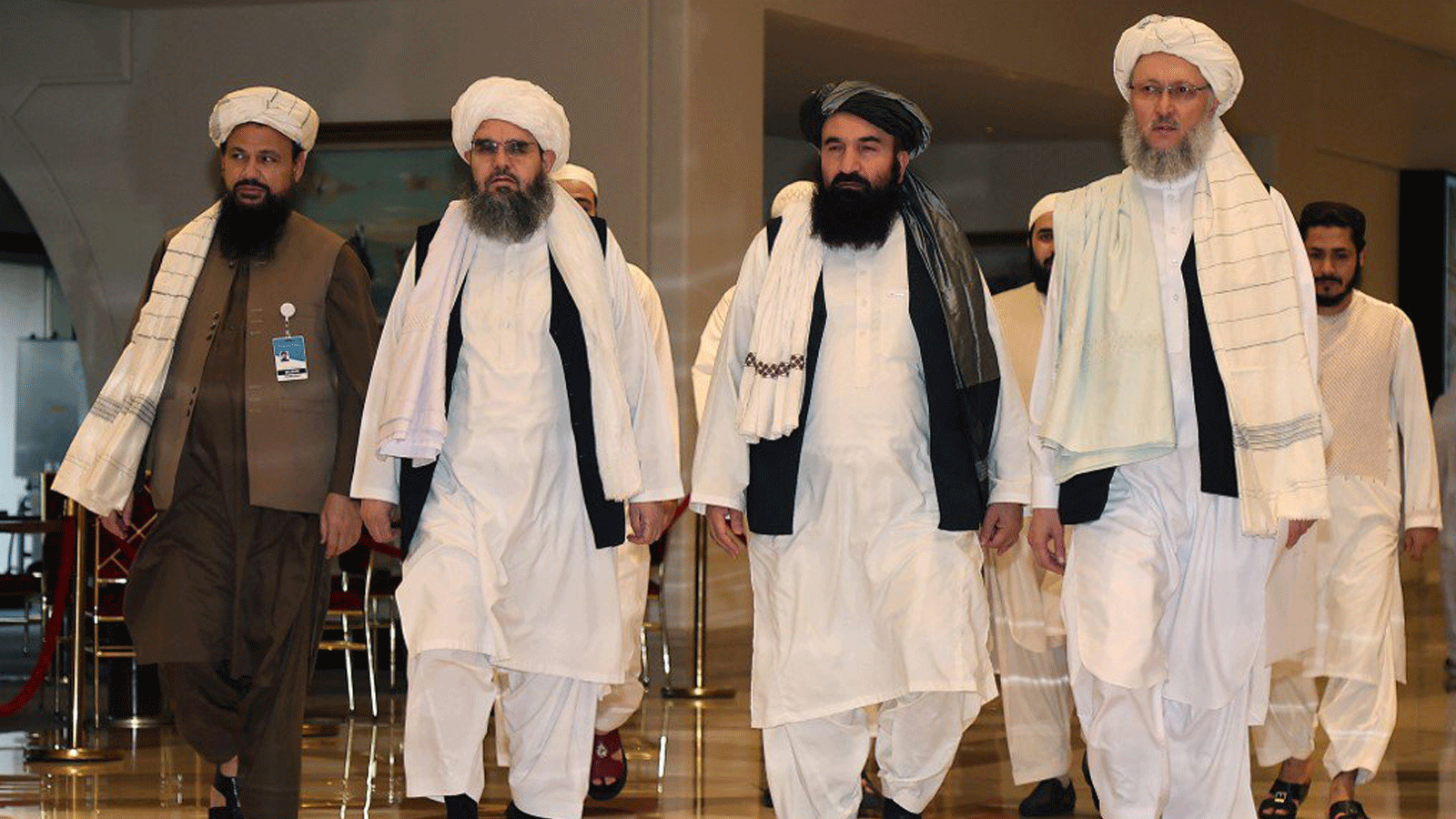مفاوضو طالبان يسيرون في بهو الفندق خلال المحادثات في العاصمة القطرية الدوحة في 12 أغسطس 2021