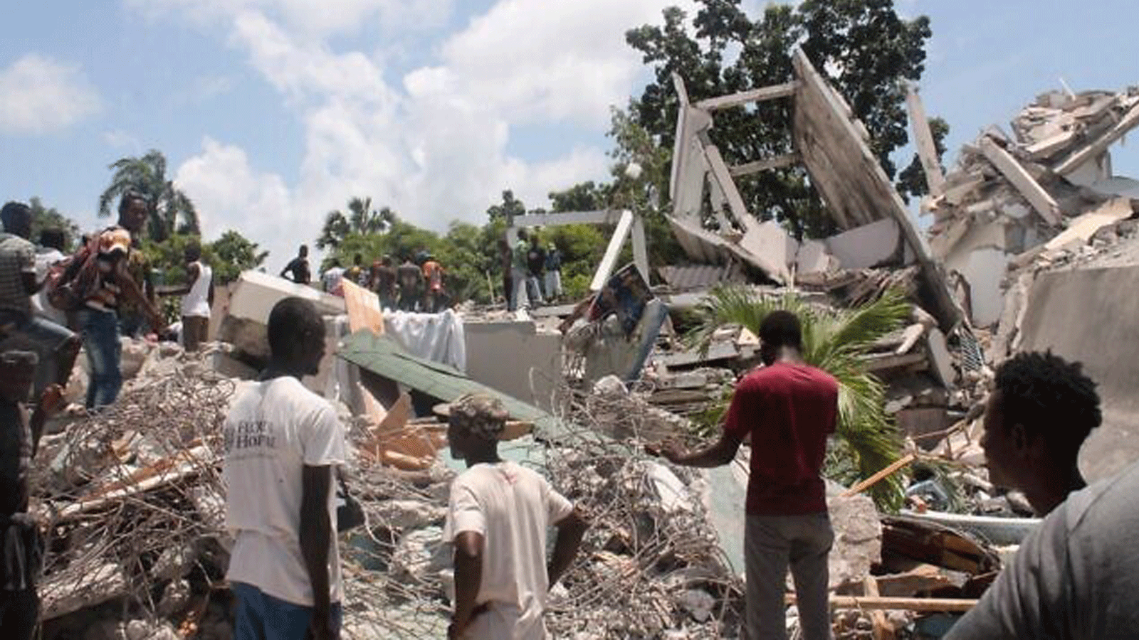  الناس يبحثون بين أنقاض ما كان يُعرف باسم فندق مانغير بعد الزلزال الذي ضرب البلاد يوم 14 آب/أغسطس 2021 في ليس كاي، جنوب غرب هايتي.