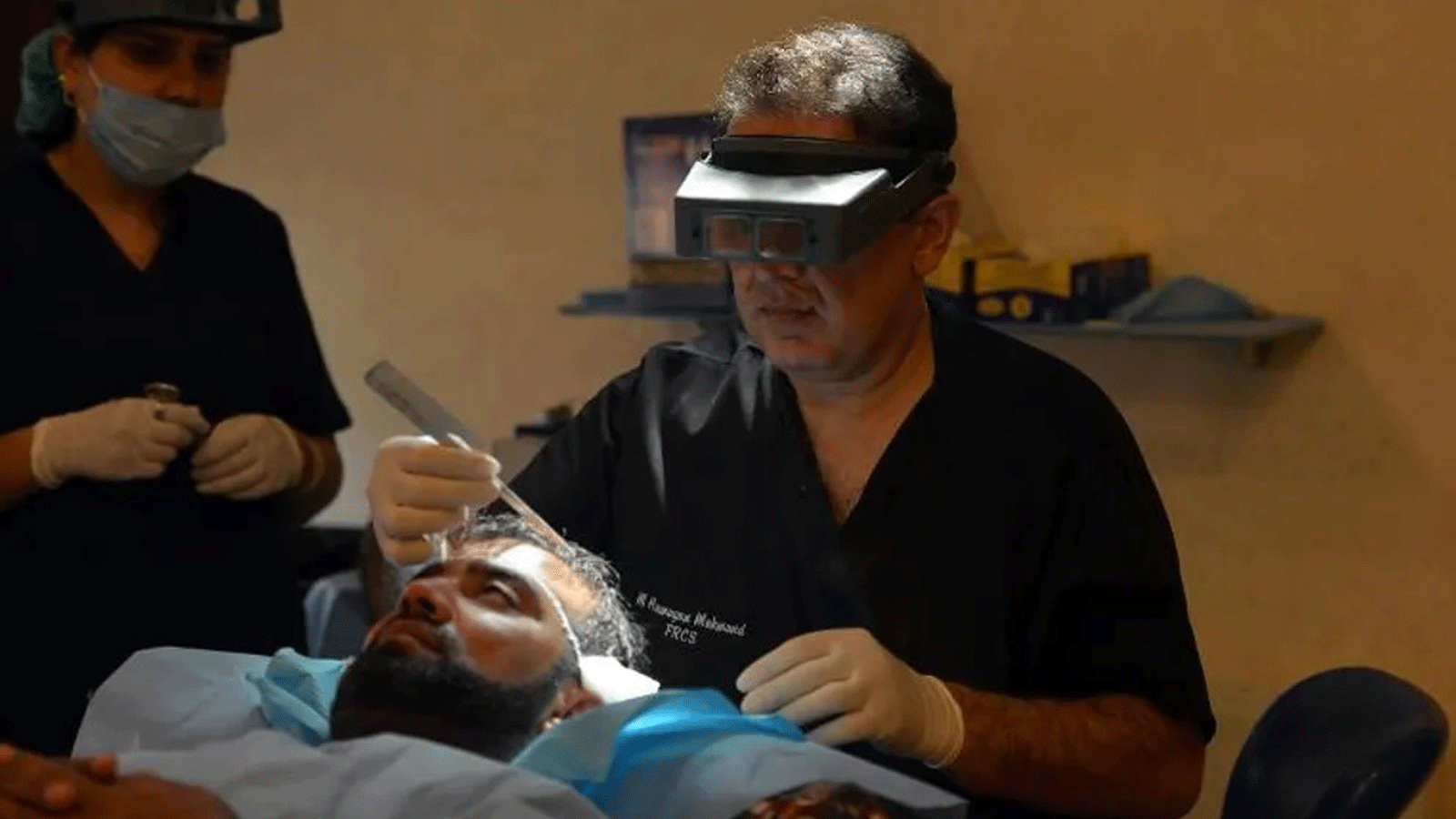 الطبيب الباكستاني همايون مهمند، يقوم بزراعة شعر لمريض في عيادته في إسلام أباد. في 16 تشرين الأول/أكتوبر 2014