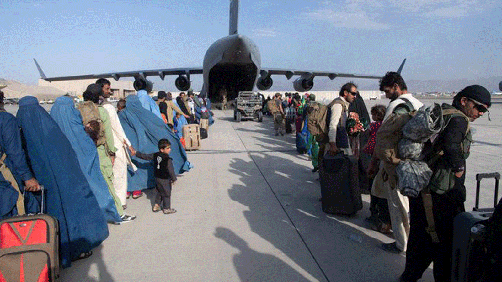 ركاب يصطفون في طابور لركوب طائرة تابعة للقوات الجوية الأمريكية C-17 Globemaster III في مطار حامد كرزاي الدولي في كابول/ أفغانستان في 24 آب/ أغسطس 2021