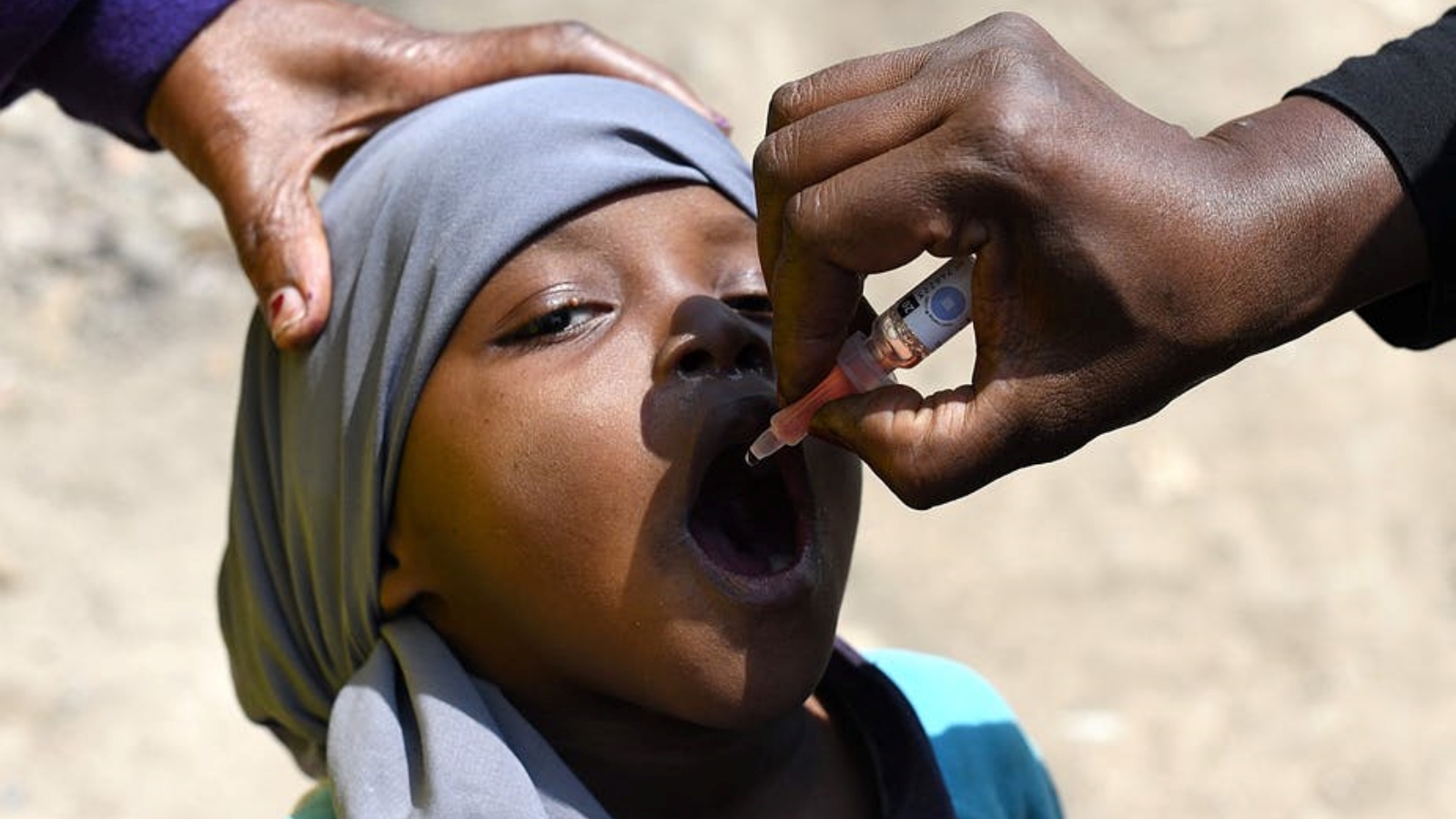 طفل يتلقى جرعة من لقاح شلل الأطفال الفموي.
