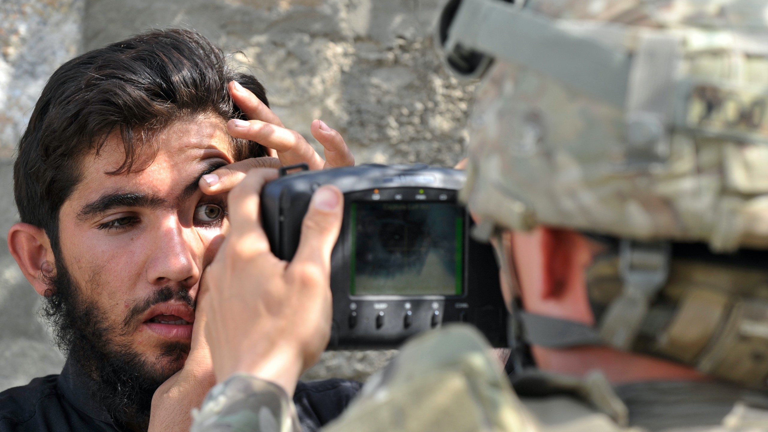 جندي أميركي يمسح بصمة عين مواطن أفغاني باستخدام نظام التعرف البيومتري الآلي خلال مهمة في تورخام في أفغانستان في 6 أكتوبر2011