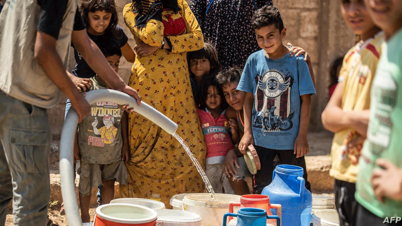 سكان يملأون دلاء بالمياه من صهاريج قدمتها منظمات إنسانية أثناء نقص المياه في مدينة الحسكة شمال شرقي سوريا. 22 آب / أغسطس 2020.