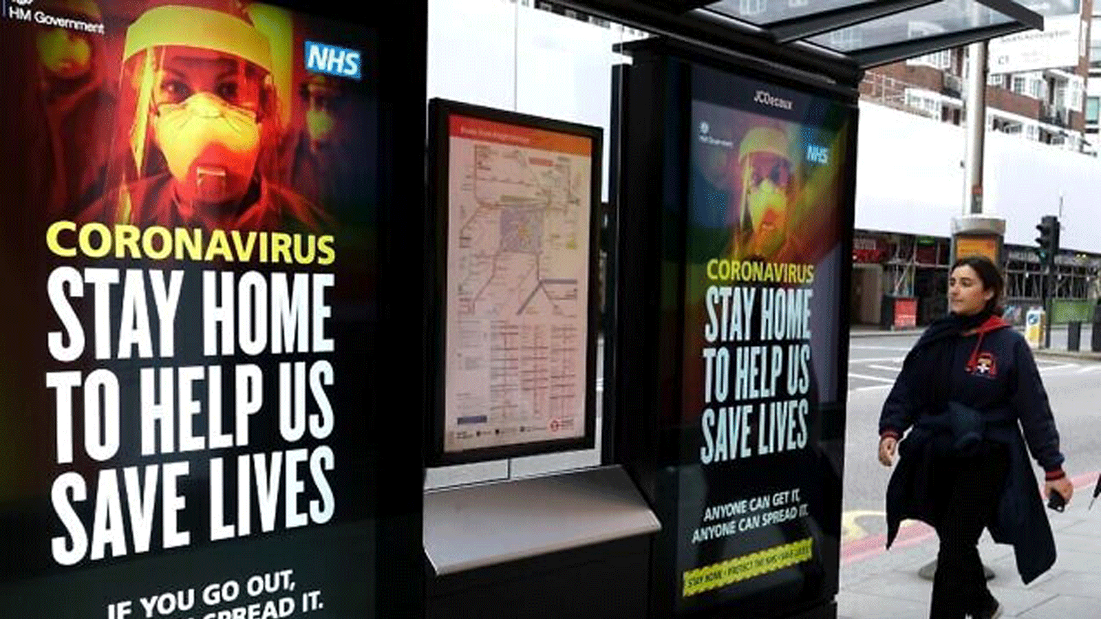  سيدة تمر عبر لافتات حول فيروس كورونا في وسط لندن في 31 آذار/ مارس 2020 خلال الإغلاق على مستوى البلاد لمكافحة جائحة COVID-19