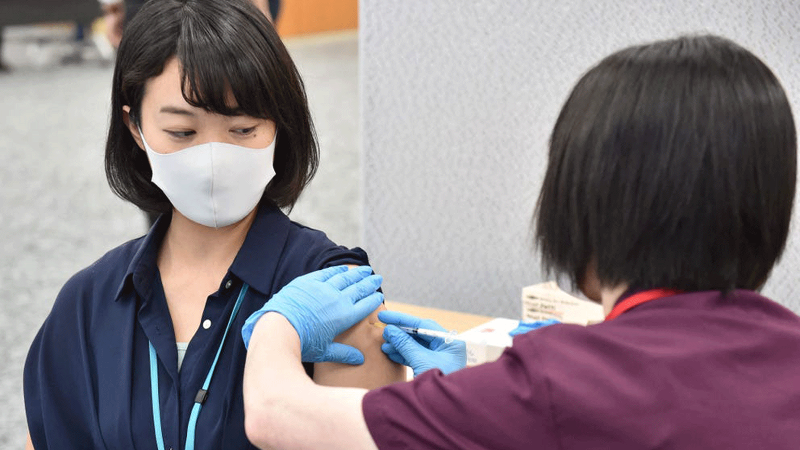 موظف في شركة Suntory Holdings اليابانية يتلقى لقاح فيروس كورونا Moderna لـ Covid-19 خلال حملة التطعيم الخاصة بالشركة في مكان العمل في مكتبهم في طوكيو في 21 حزيران/ يونيو 2021.