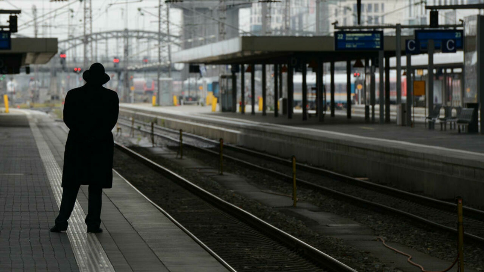 رجلٌ ينتظر قطار شركة السكك الحديدية الوطنية الألمانية دويتشه بان في محطة القطار المركزية في ميونيخ.