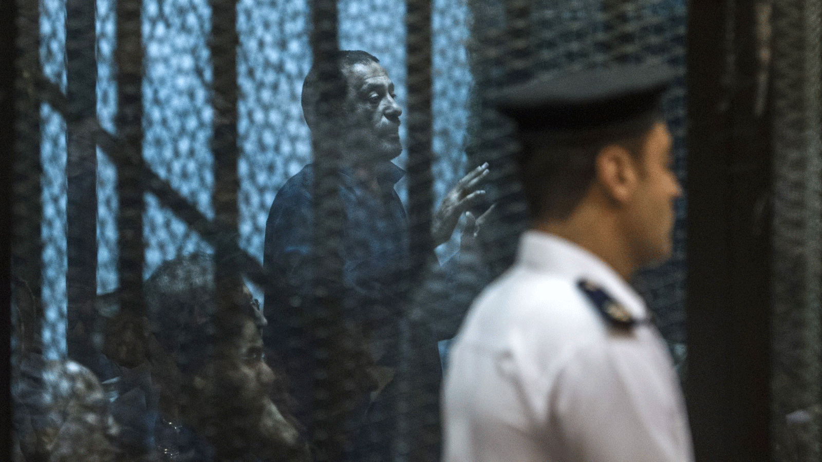  القيادي في جماعة الإخوان المسلمين أحمد أبو بركة خلف قفص المدعى عليه أثناء المحاكمة بتهمة إهانة القضاء مع 25 متهمًا آخر. القاهرة 23 أيار/ مايو 2015