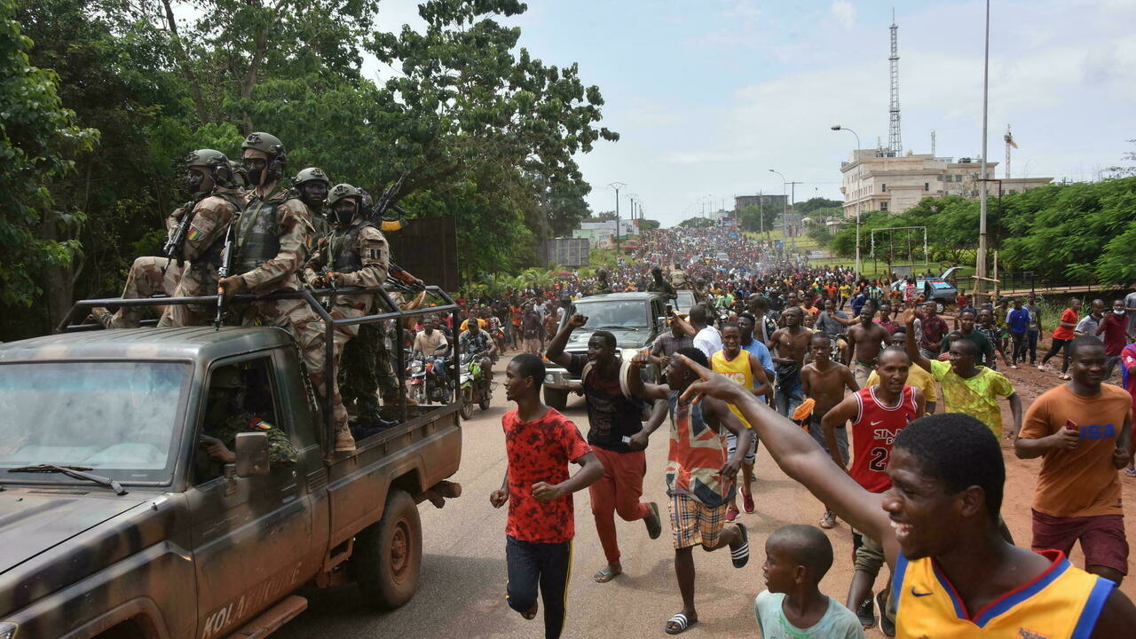 معارضون يحتفلون في الشوارع مع أفراد القوات المسلحة بعد اعتقال رئيس غينيا ألفا كوندي ، في انقلاب في كوناكري، 5 أيلول/سبتمبر 2021