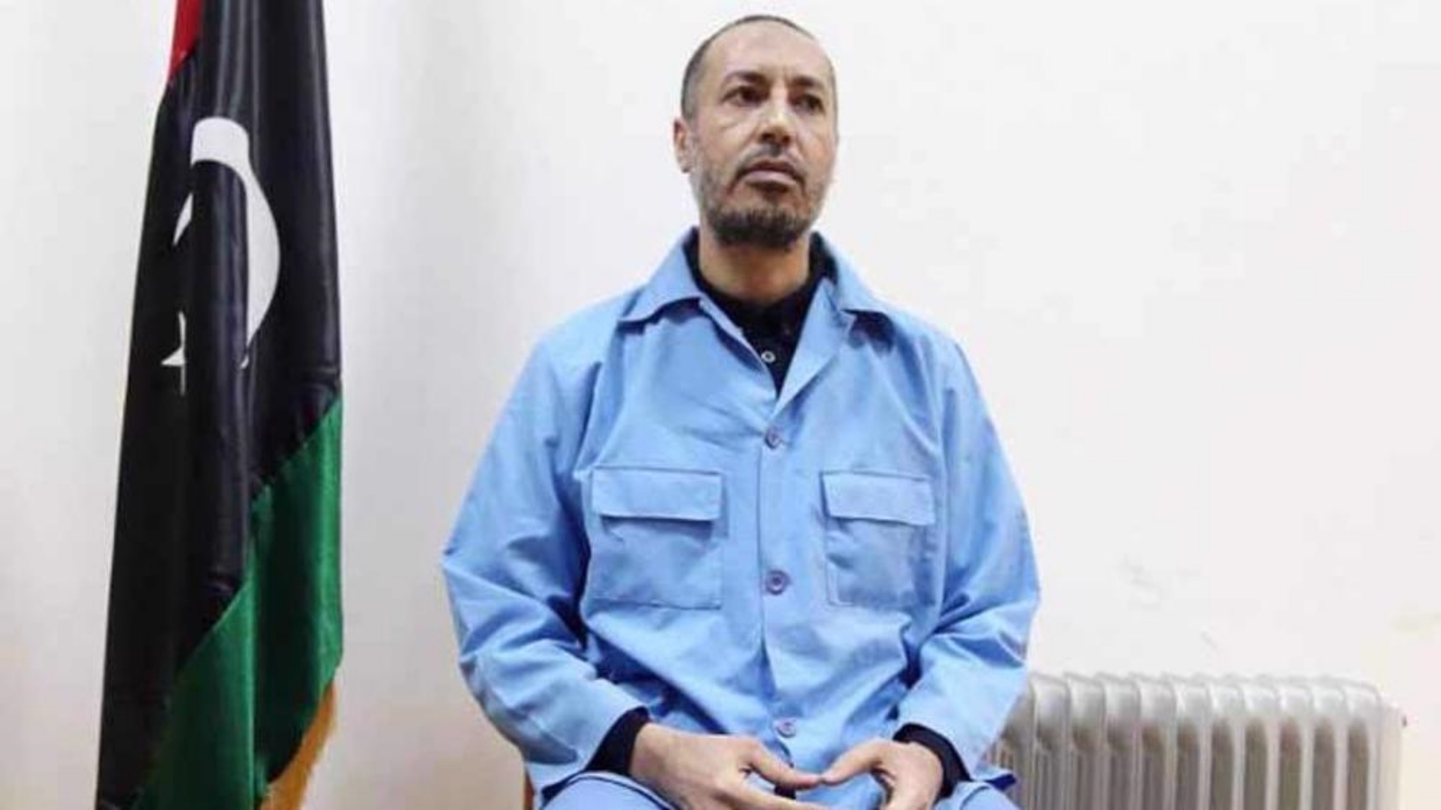 الساعدي القذافي، نجل الزعيم الليبي السابق معمر القذافي، مرتديًا ملابس السجن بانتظار المحاكمة في محكمة بالعاصمة الليبية، طرابلس. بتاريخ 13 أذار/ مارس 2016.