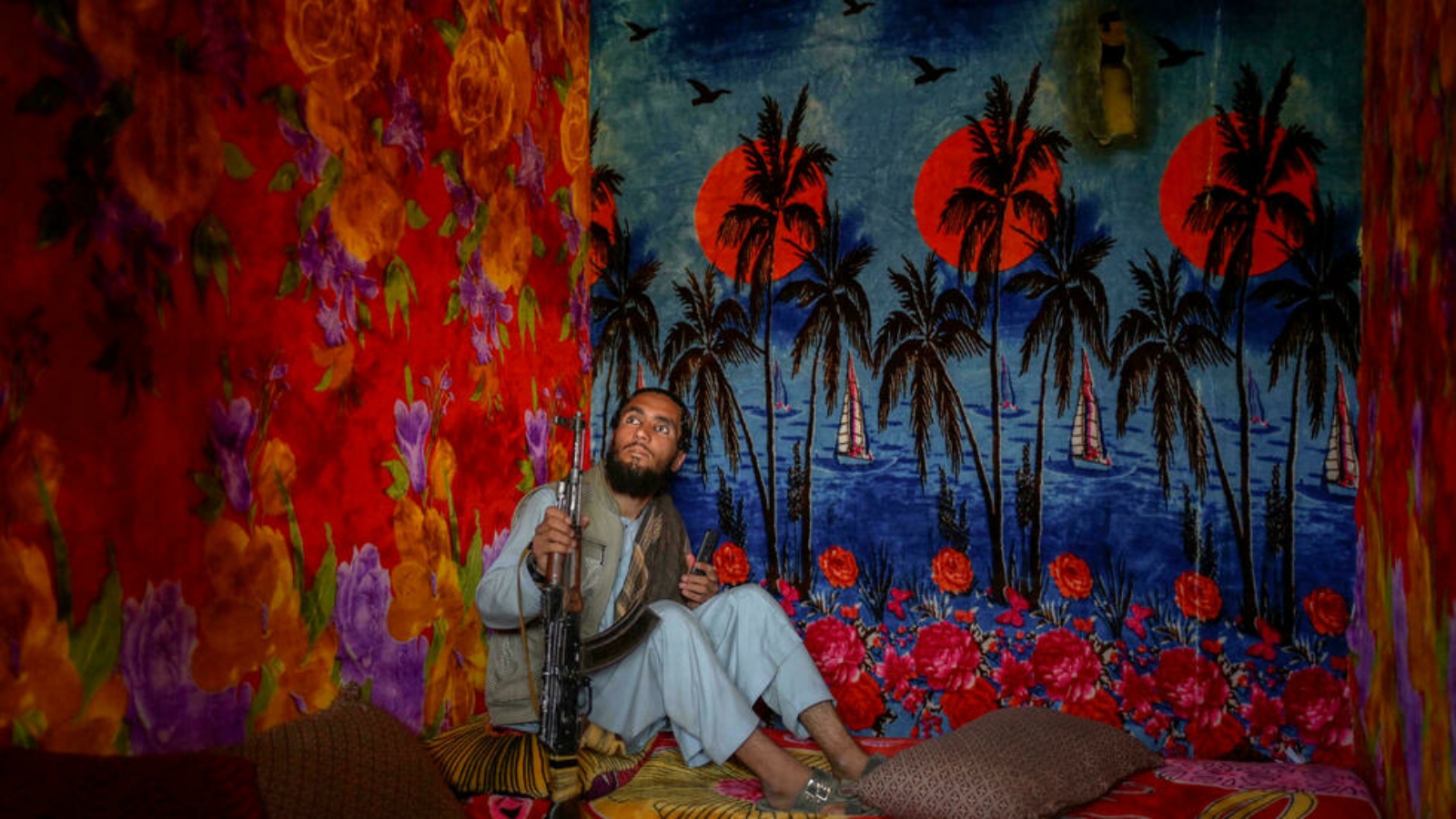 عنصر من طالبان في زنزانة حيث أُلصقت أوراق جدران تعكس غياب الشمس في مناطق استوائية