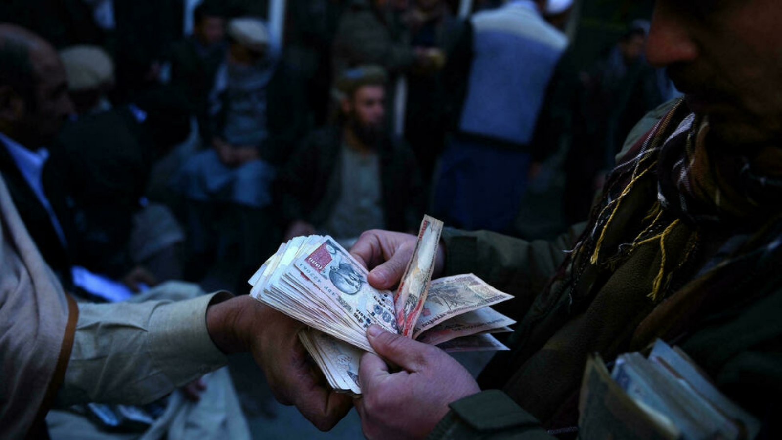 مقاتل من طالبان يقوم بعدّ الأموال في أفغانستان.