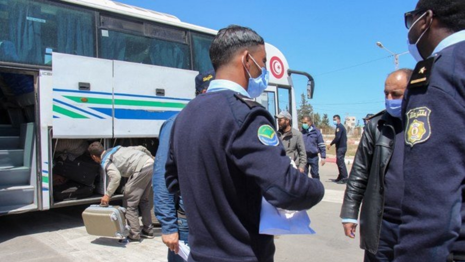 عناصر من الشرطة يتفقدون الأوراق الثبوتية للمسافرين عبر الحدود المشتركة بين ليبيا وتونس.