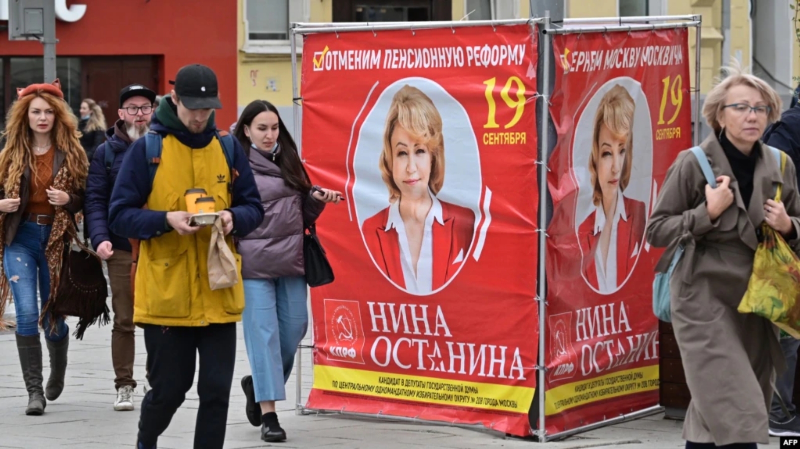 مواطنون يمرون بجانب ملصق لحملة مرشح الحزب الشيوعي الروسي في موسكو. بتاريخ 16 أيلول/ سبتمبر 2021.