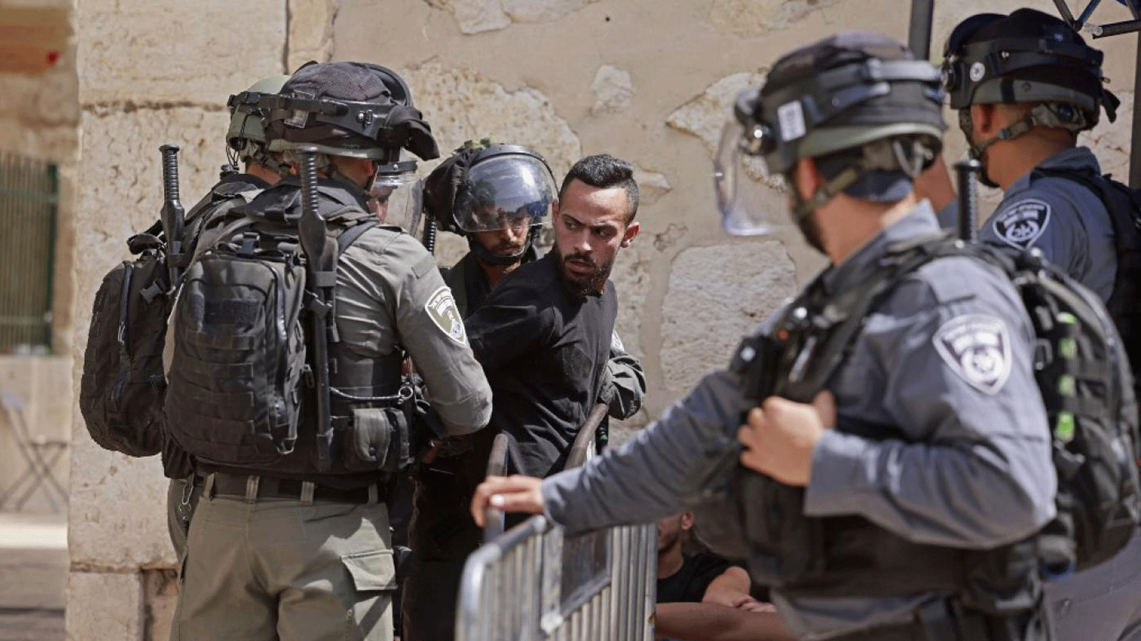قوات الأمن الإسرائيلية تفتش رجلاً عند مدخل المسجد الأقصى في القدس يوم 21 أيار/ مايو 2021