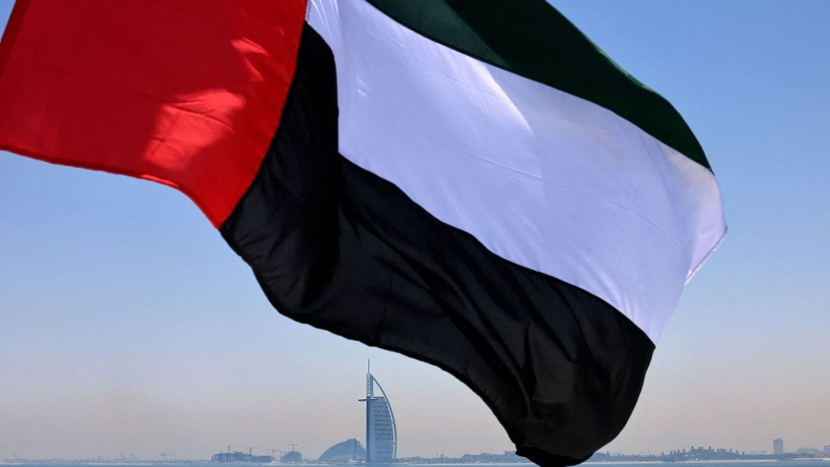 العلم الإماراتي مرفرفًا ويظهر برح العرب في خلفية الصورة 