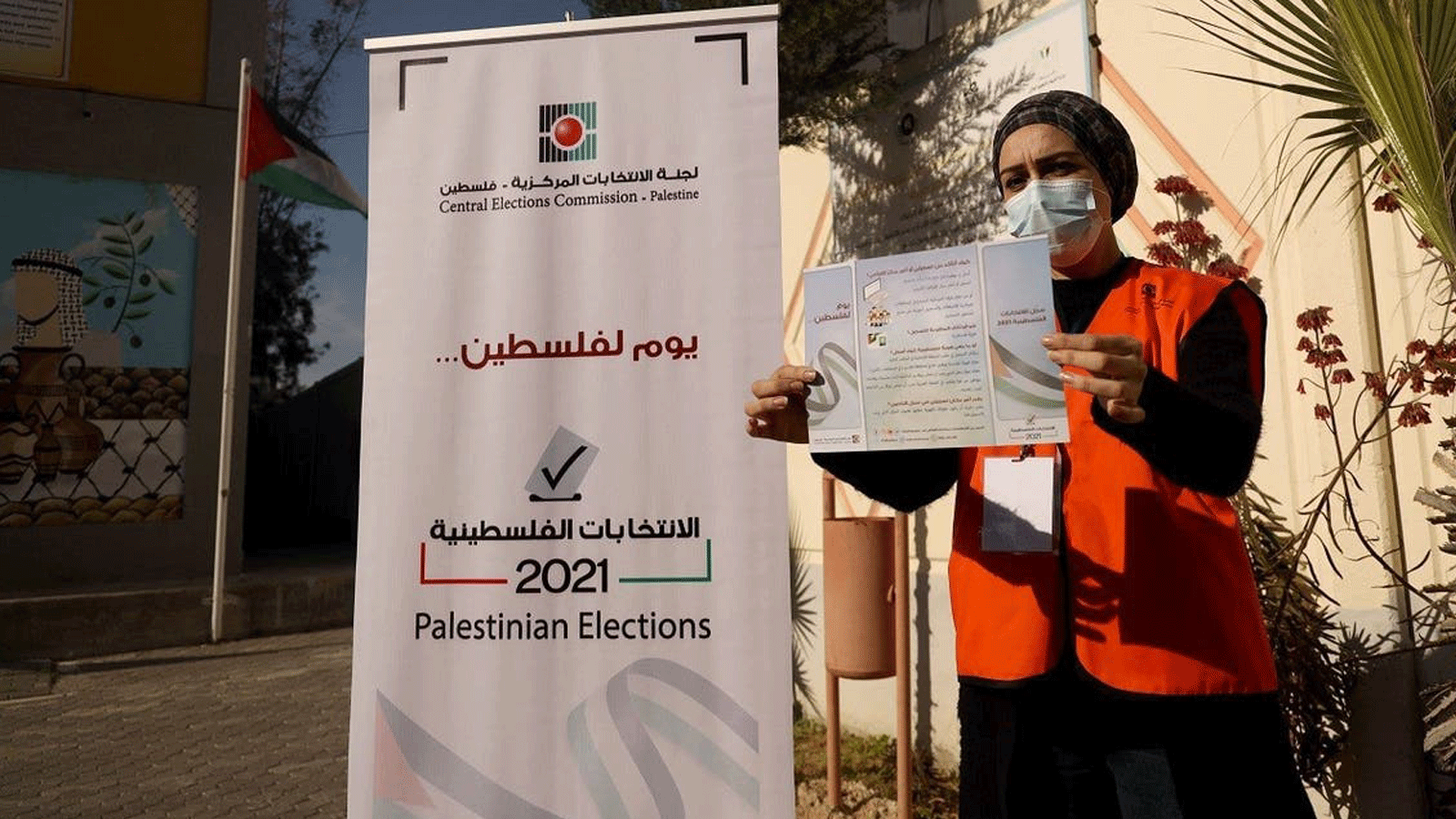 سيدة فلسطينية هي عضو في لجنة الانتخابات المركزية تعرض نشرة إعلامية بعد افتتاح مركز معلومات وتسجيل الناخبين الأول في مدينة غزة في 10 شباط /فبراير2021