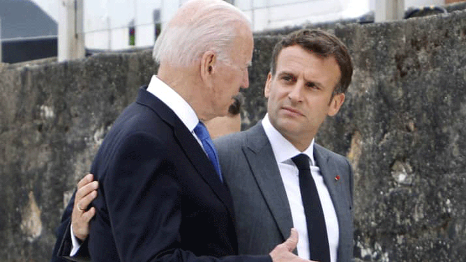  الرئيس الأميركي جو بايدن (إلى اليسار) والرئيس الفرنسي إيمانويل ماكرون يتحدثان بعيد التقاط الصورة الجامعة في بداية قمة مجموعة السبع في خليج كاربيس/ كورنوال. 11 حزيران/ يونيو 2021