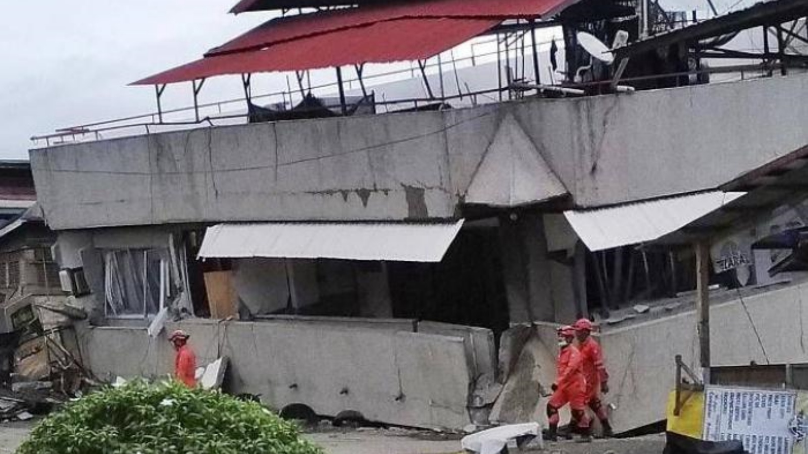 رجال إنقاذ بجانب منزل مدمر بفعل الزلزال الذي ضرب الفيليبين. بتاريخ 27 أيلول/ سبتمبر 2021.