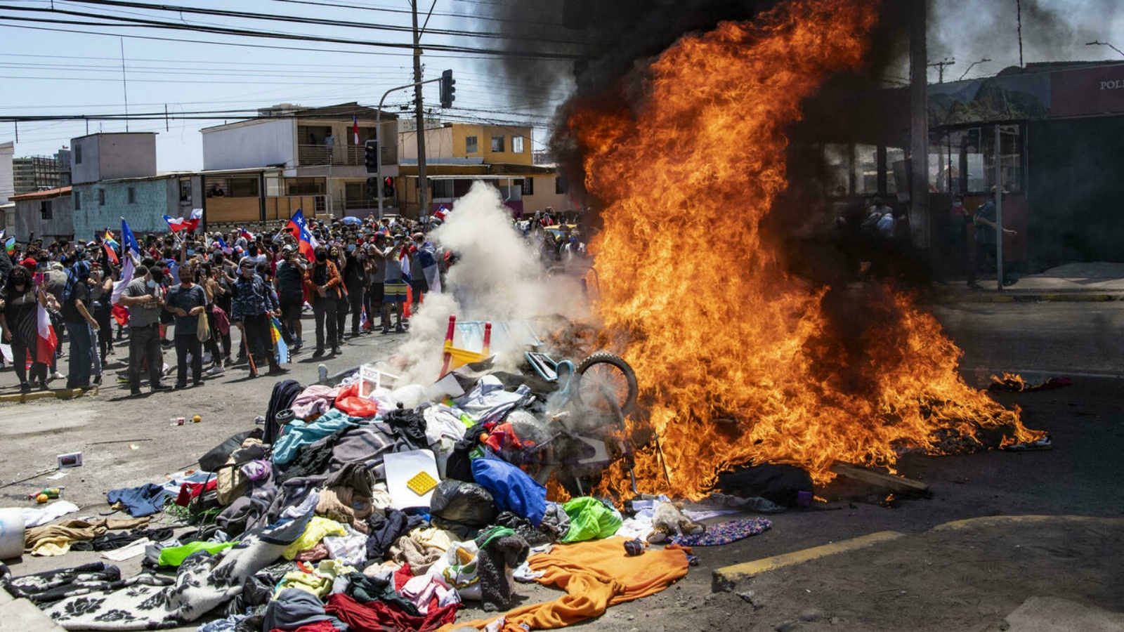 متظاهرون يحرقون ممتلكاتهم في مخيم مؤقت للمهاجرين الفنزويليين خلال احتجاج في إكيكي، تشيلي. في 25 أيلول/ سبتمبر 2021