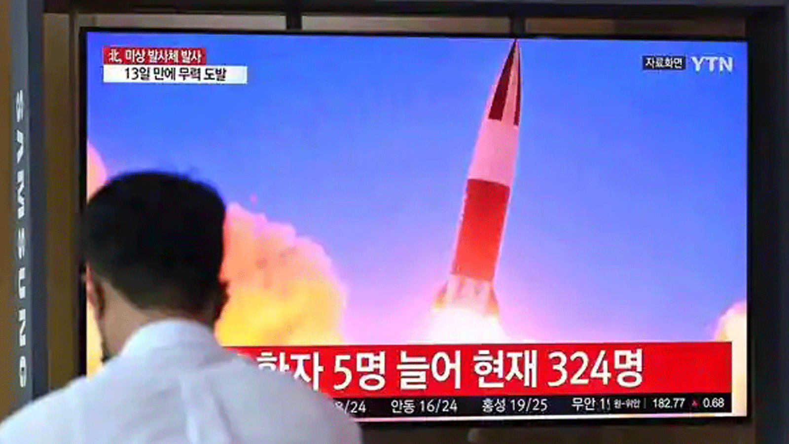 مواطنوان يشاهدون نشرة إخبارية تلفزيونية تعرض لقطات لصاروخ كوري شمالي