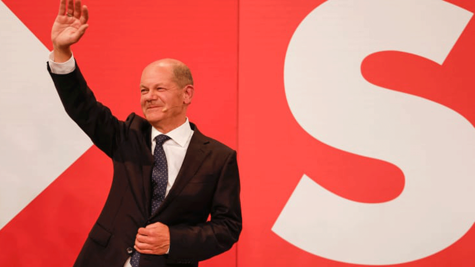 أولاف شولتز يلوح لمؤيديه في مقر الحزب الاشتراكي الديمقراطي (SPD) بعد أن بثت التقديرات بفوزه في برلين في 26 أيلول/ سبتمبر 2021 بعيد الانتخابات العامة الألمانية