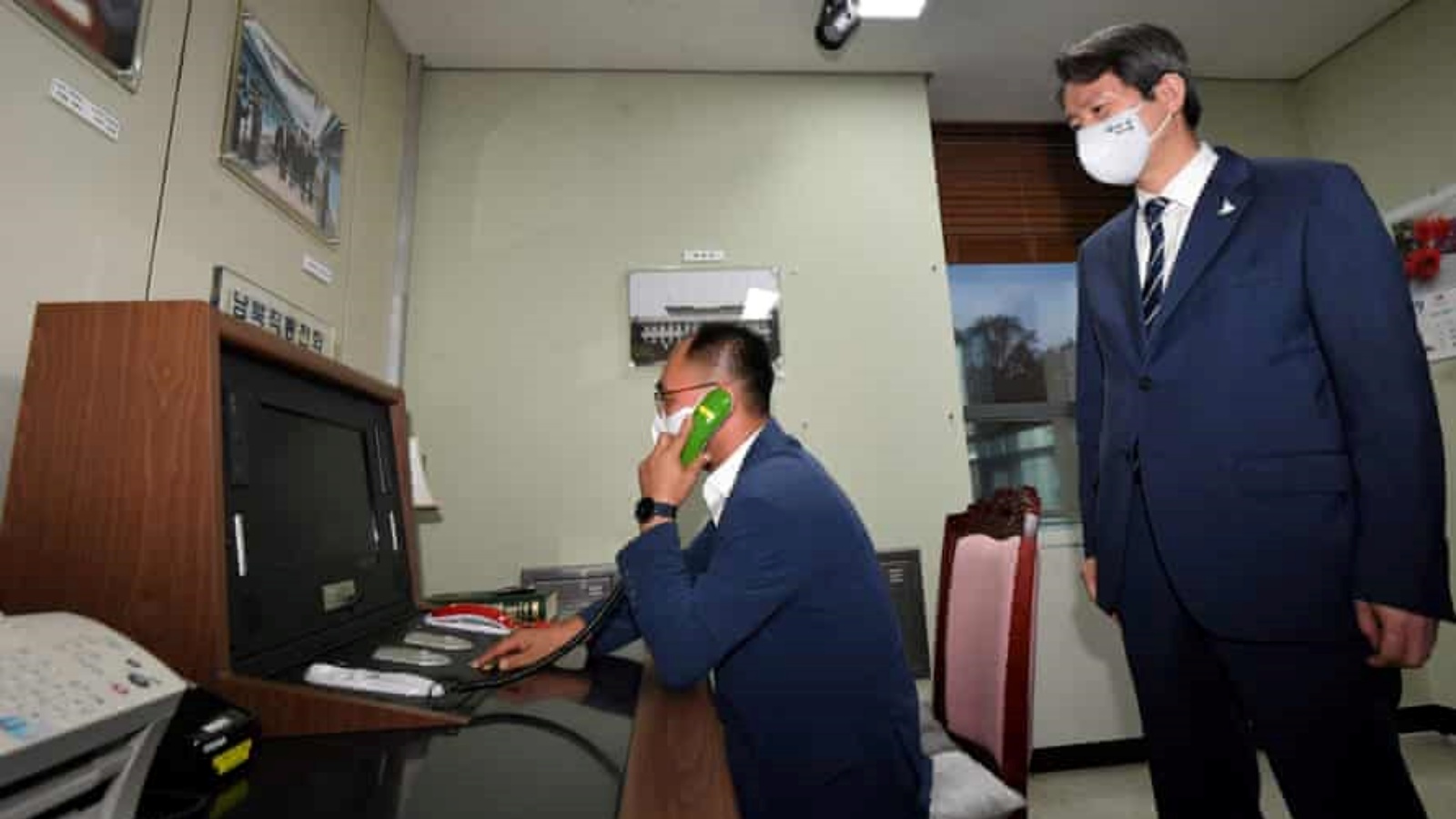 وزير التوحيد في كوريا الجنوبية لي إن يونغ (يمين) يزور الخط الساخن في أيلول/ سبتمبر من العام الماضي خلال زيارة إلى الجانب الجنوبي من قرية الهدنة بانمونجوم.