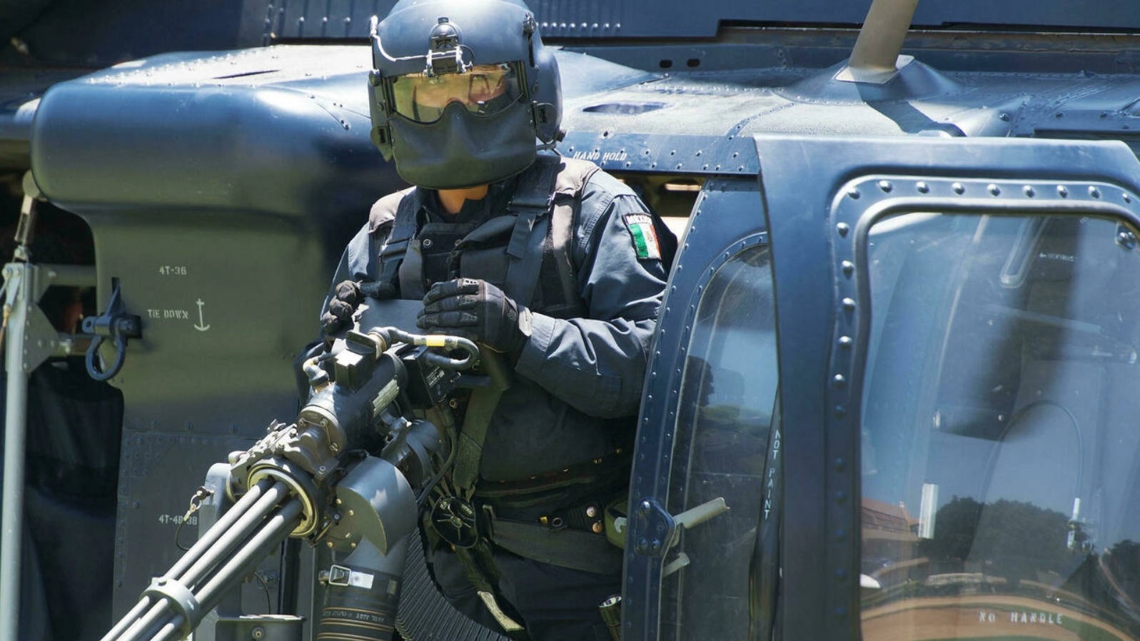 جندي أميركي بجانب طائرة هليكوبتر مزوّدة بأسلحة رشاشة تستخدمها الولايات المتحدة لمحاربة عصابات المخدرات.