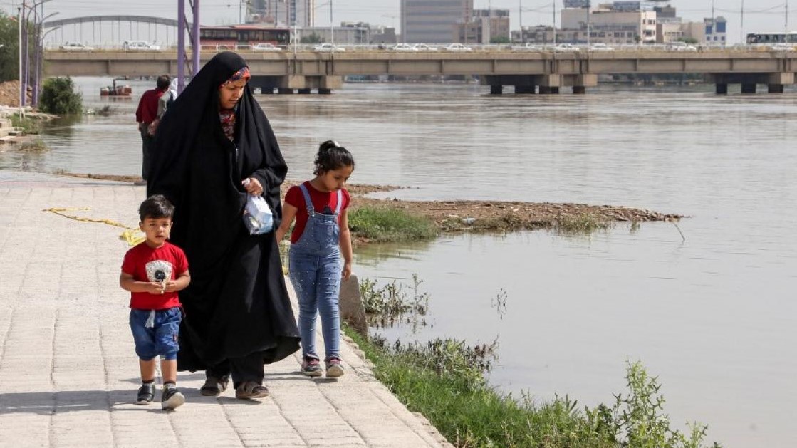 امرأة تمشي مع أطفالها على طول نهر كارون في الأهواز عاصمة محافظة خوزستان جنوب غرب إيران