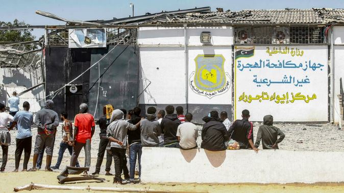 مهاجرون خارج مركز احتجاز مهاجرين في ضاحية تاجوراء بالعاصمة الليبية طرابلس بتاريخ 3 يوليو 2019 