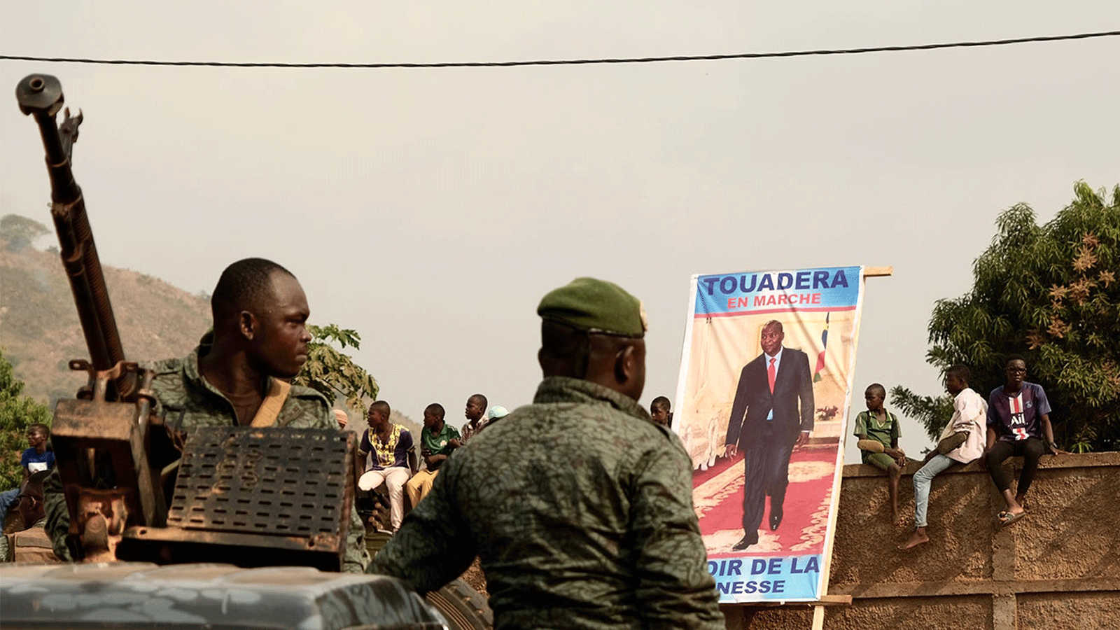 الحرس الرئاسي يقف في بانغي ، في 12 كانون الأول/ديسمبر 2020 ، خلال التجمع الانتخابي الافتتاحي للرئيس الحالي فوستين أرشانج تواديرا ، الذي يظهر في الملصق