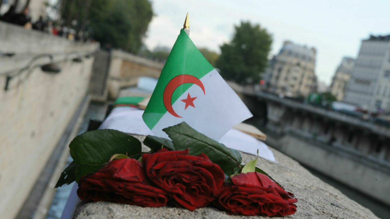 العلم الجزائري وورود حمراء عند جسر سان ميشال في باريس في إطار إحياء ذكرى مظاهرة 17 أكتوبر 1961 عام 2009