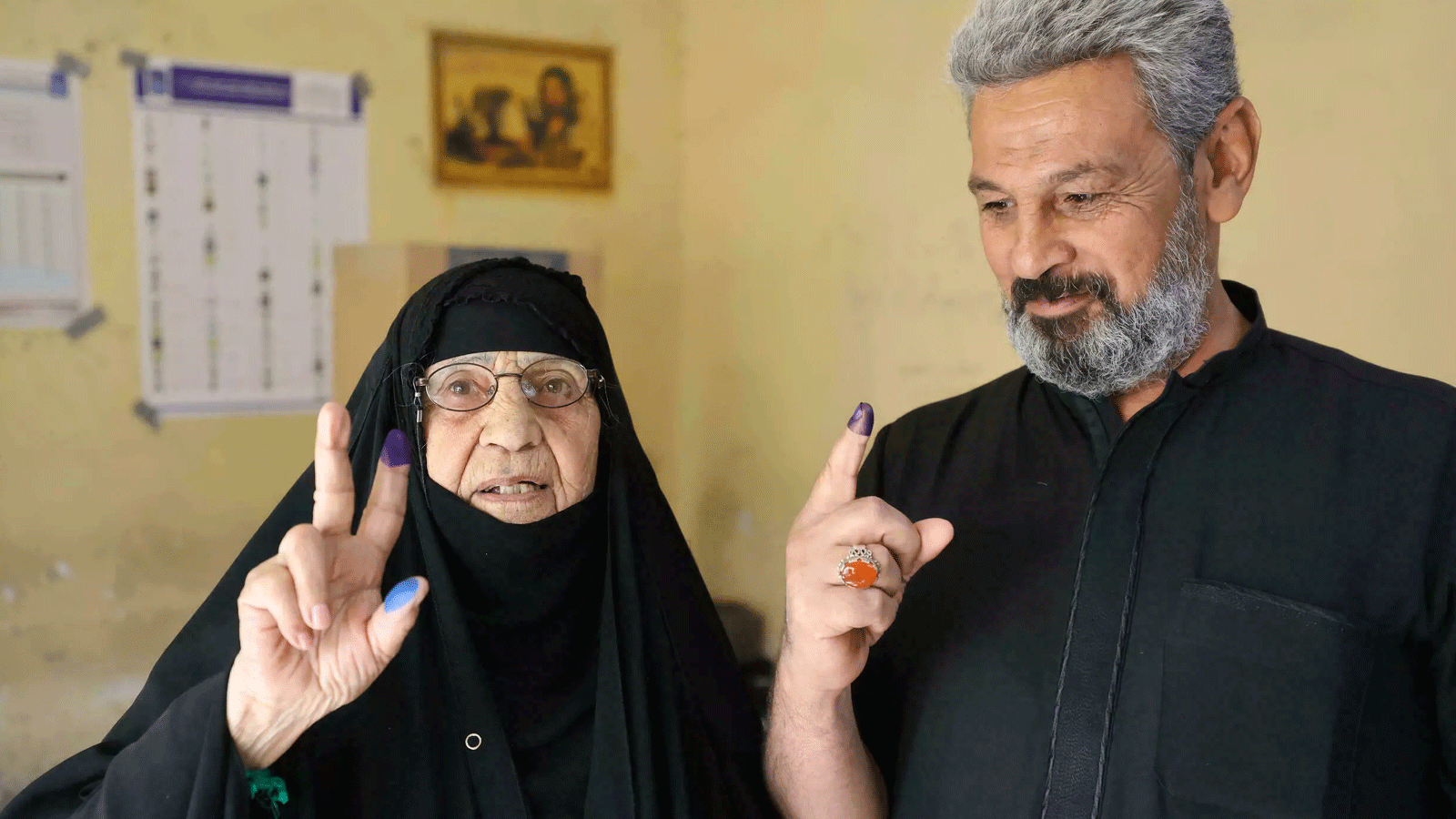 عراقيون يظهرون أصابعهم بالحبر بعد التصويت في مركز اقتراع في بغداد