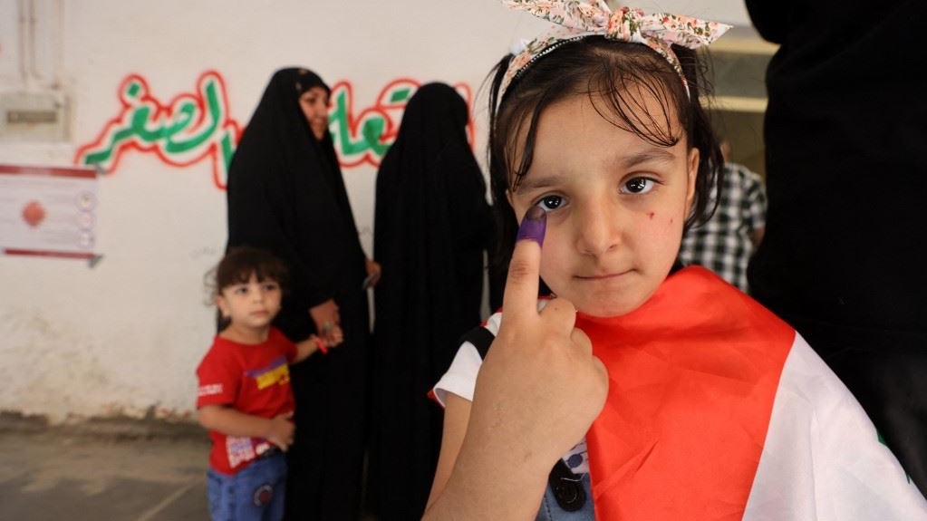 طفلة عراقية ترفع إصبعها بدلالة على مشاركتها رمزيّاً في الانتخابات العراقية 