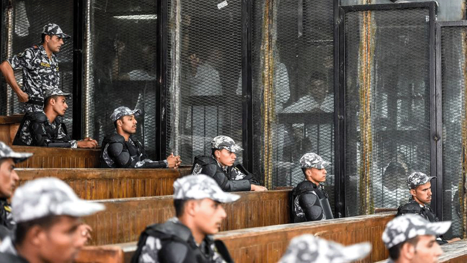 أعضاء من جماعة الإخوان المسلمين المحظورة في مصر خلف الزجاج أثناء محاكمتهم في القاهرة. 28 تموز/ يوليو 2018. 