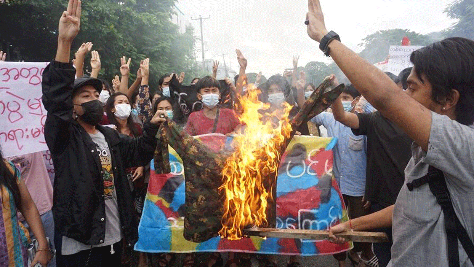 صورة تم التقاطها في 1 تموز/يوليو 2021 لمتظاهرين يحرقون زياً عسكرياً أثناء مشاركتهم في مظاهرة ضد الانقلاب العسكري في يانغون.