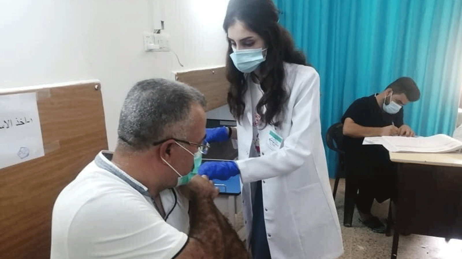 طبيبة تُلقّح عراقياً ضد فايروس كورونا مع تحذير وزارة الصحة اليوم الاثنين من موجة رابعة للجائحة (الصحة العراقية)