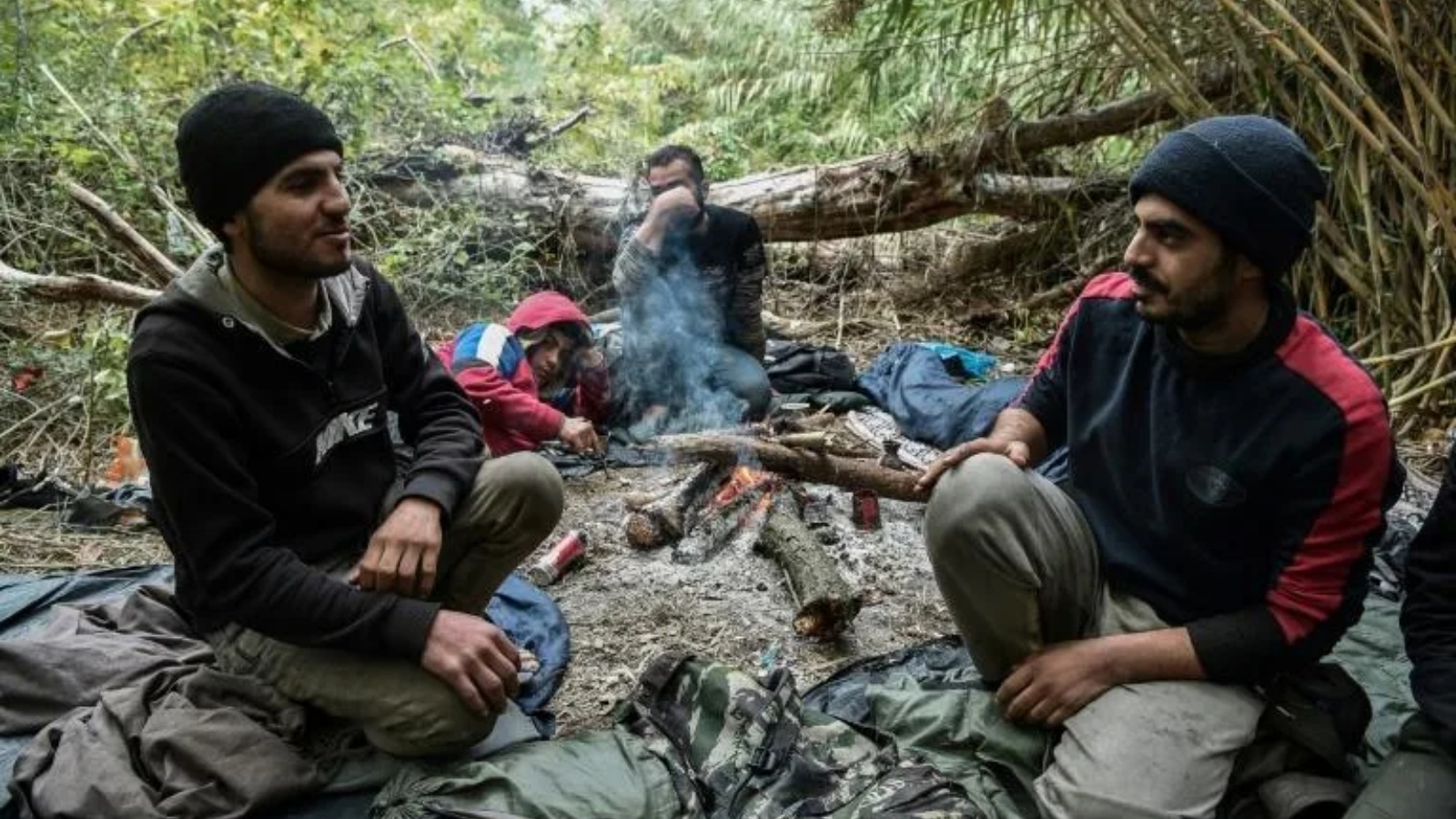 مهاجرون يحاولون تدفئة أنفسهم بنيران بالقرب من إيدوميني على الحدود بين اليونان ومقدونيا الشمالية.