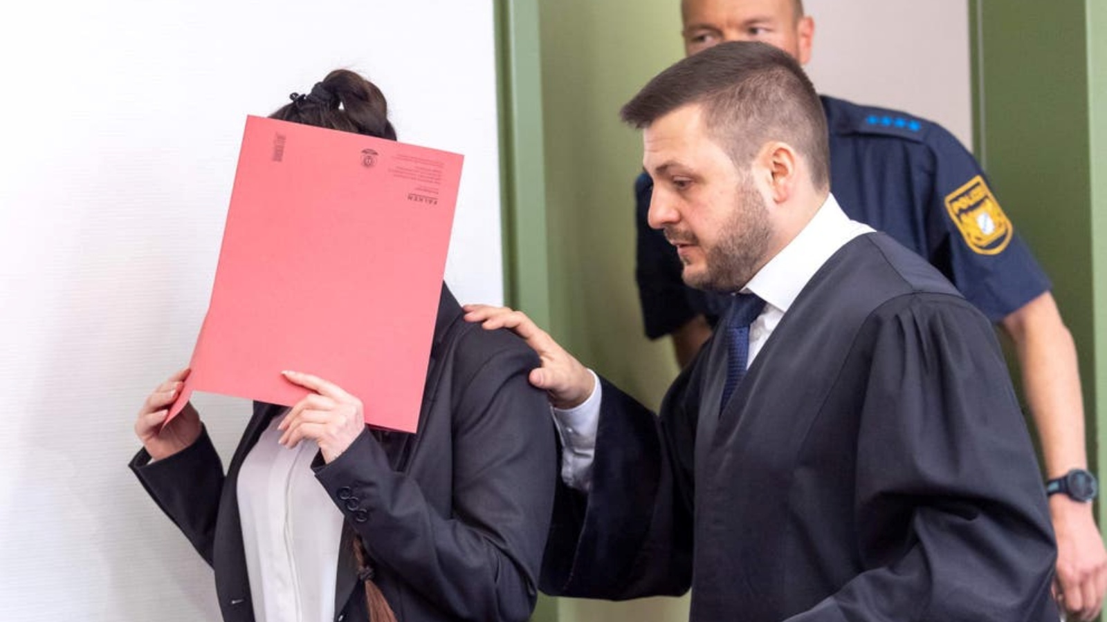 المدعى عليها جينيفر فينيش تخفي وجهها خلف ملف وتمشي بجانب محاميها. (أرشيفية)