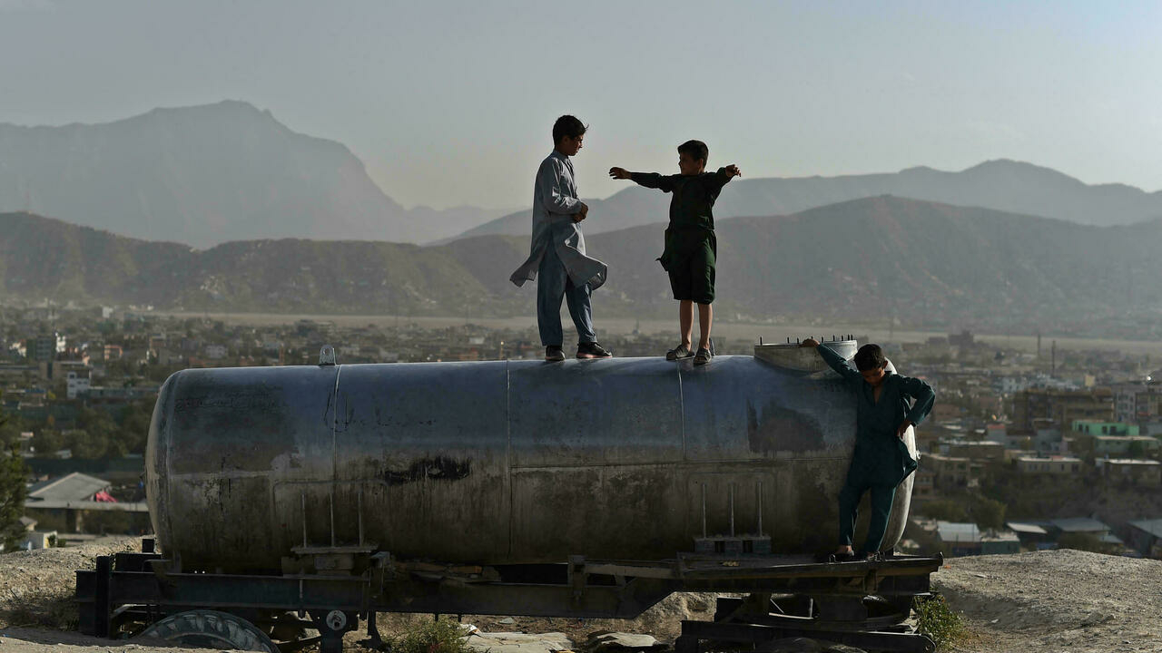أولاد أفغان يلعبون فوق صهريج ماء على تلة تطل على كابول في 10 تشرين الأول/أكتوبر 2021
