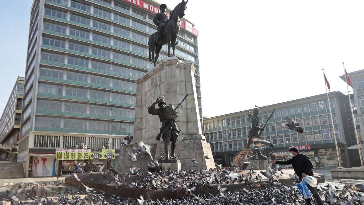 رجل يطعم الحمام في ساحة أولوس المقفرة في أنقرة في 9 يناير 2021
