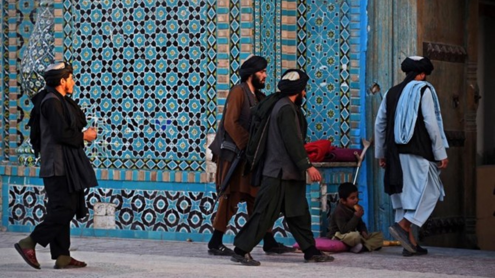 مقاتلو طالبان يسيرون عبر بوابة دخول ضريح حضرة علي أو المسجد الأزرق في مزار الشريف. في 30 تشرين الأول/أكتوبر 2021.