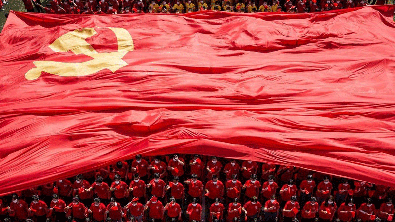 طلاب جامعيون في ووهان يرفعون علم الحزب الشيوعي الصيني بمناسبة الذكرى المئوية لتأسيسه.