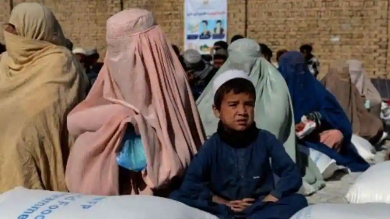 أفغان يصطفون بجانب أكياس الحبوب الغذائية التي وزعها برنامج الأغذية العالمي كمساعدة في قندهار، أفغانستان. في 19 تشرين الأول/أكتوبر 2021